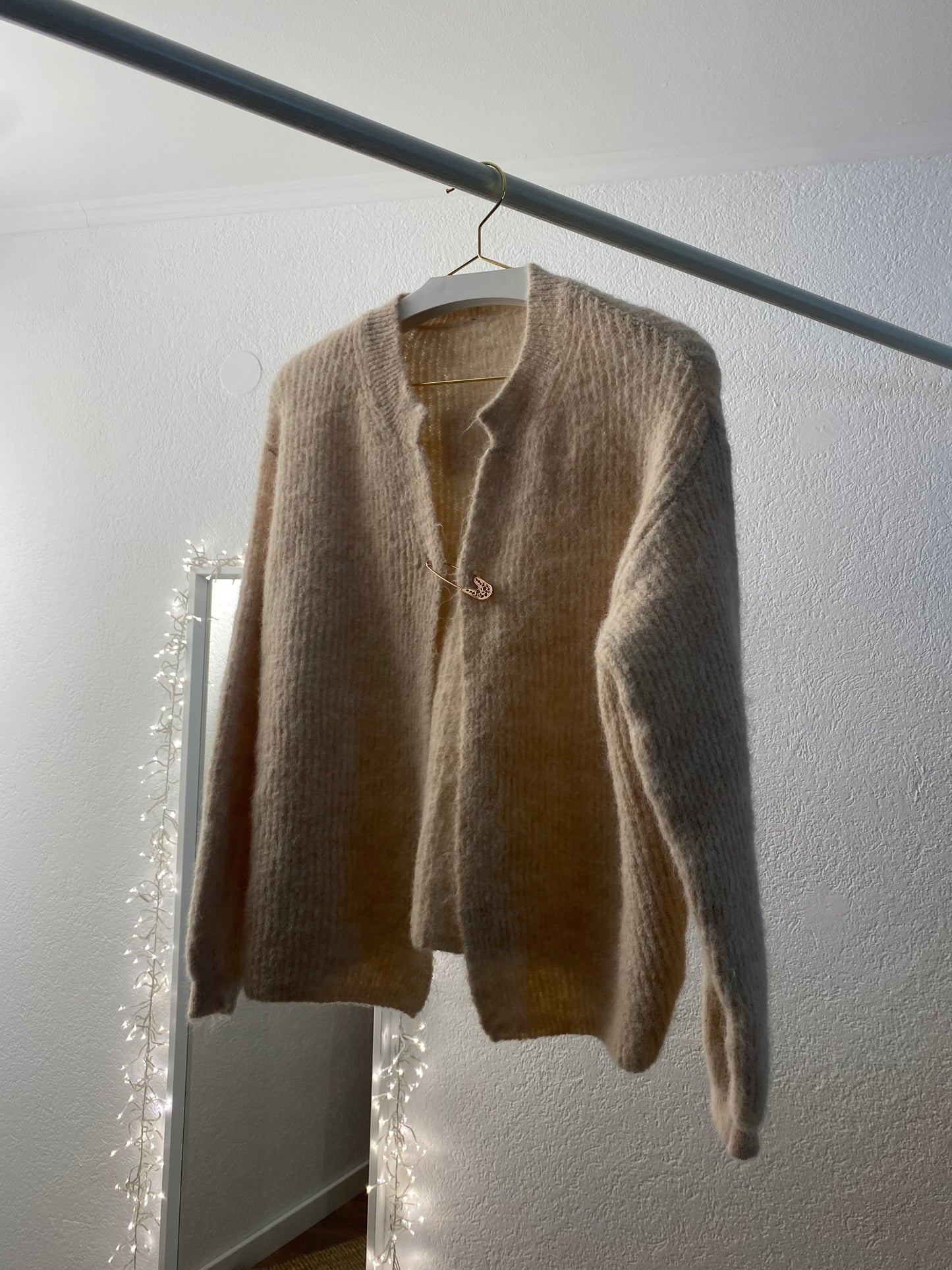 Strickjacke mit goldener Sicherheitsnadel